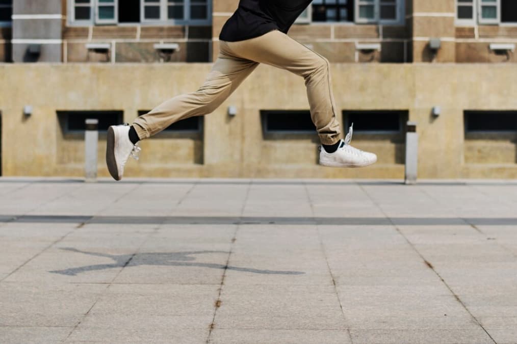 Legs captured mid-jump above an urban square
